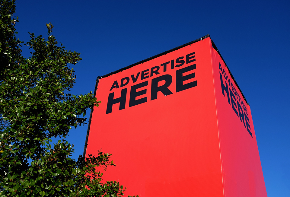 Blank, red, outdoor billboard labelled "Advertise Here"